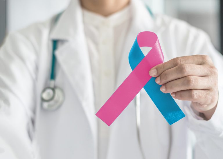 birth defect awareness month. Doctor holding a blue and pink ribbon.