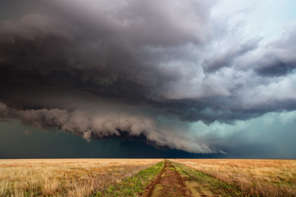 Severe Weather Dramatic clouds and stormy sky with a thunderstorm over a dirt road and field in Kansas.