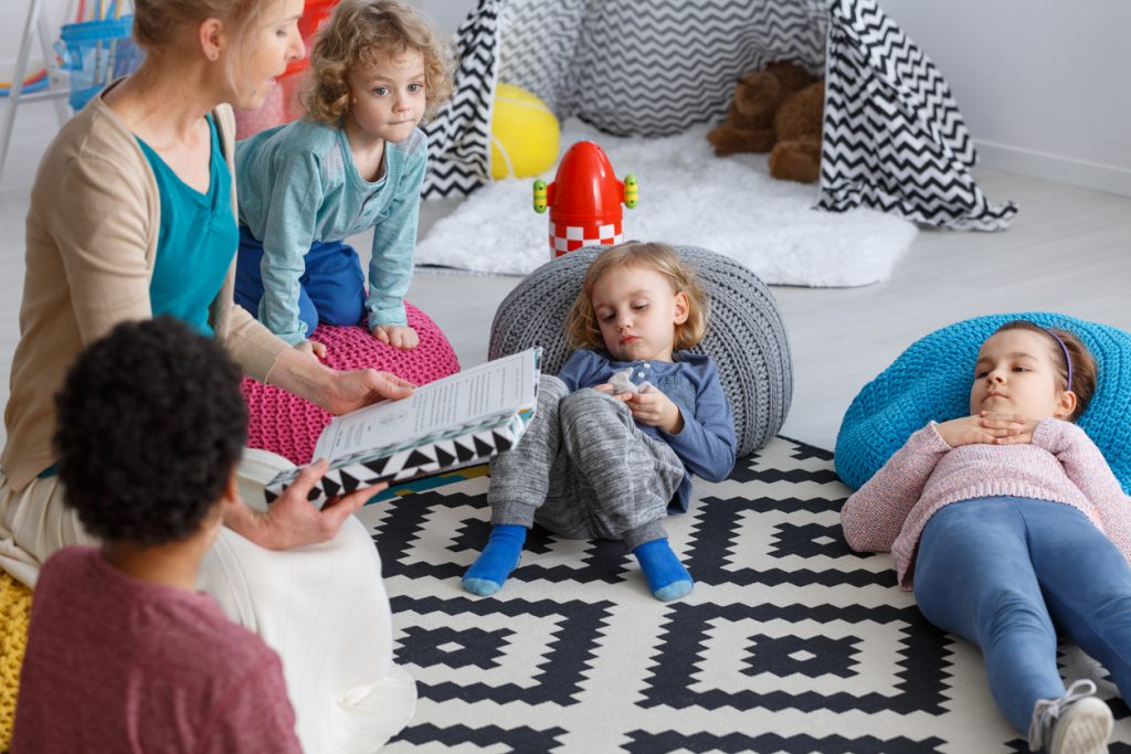 Teacher reading to kids druring nap time.